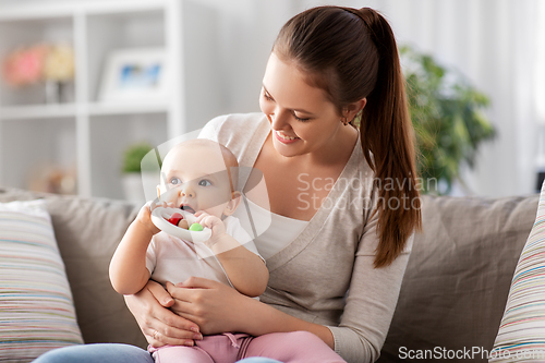 Image of mother and little baby with teething toy at home