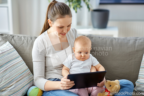 Image of happy mother and baby girl with tablet pc at home