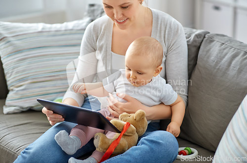 Image of happy mother and baby girl with tablet pc at home