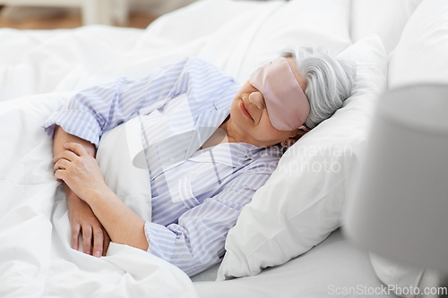 Image of senior woman with eye mask sleeping in bed at home