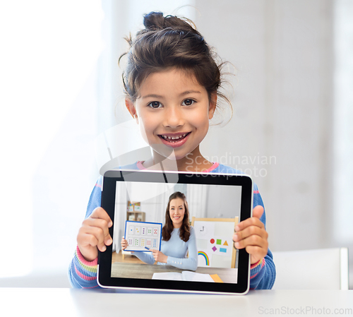Image of little girl with teacher on tablet pc at home