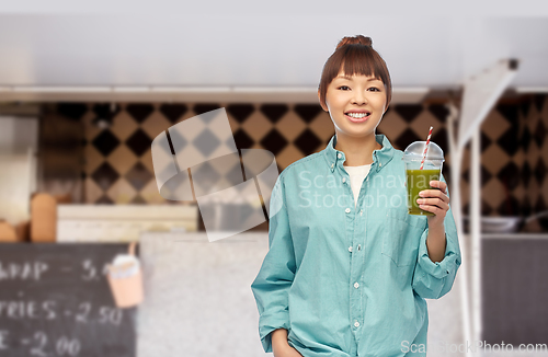 Image of happy asian woman with juice over food truck