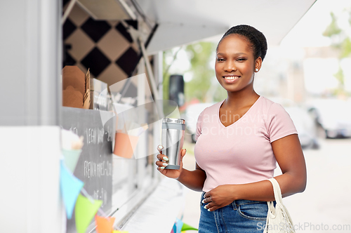 Image of woman with tumbler and food in string bag