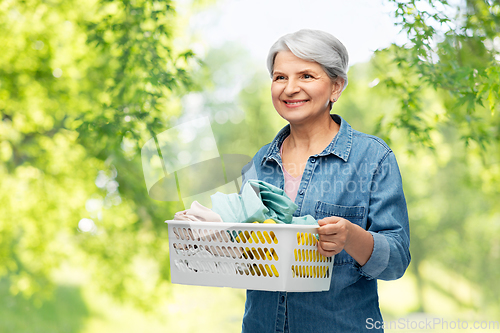 Image of smiling senior woman with laundry basket