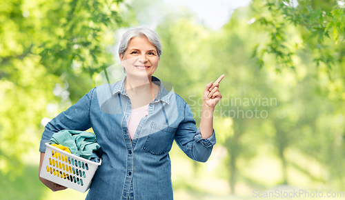 Image of smiling senior woman with laundry basket