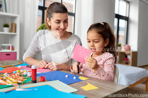 Image of daughter with mother making applique at home