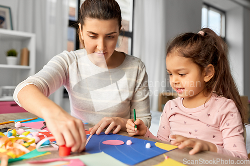 Image of daughter with mother making applique at home