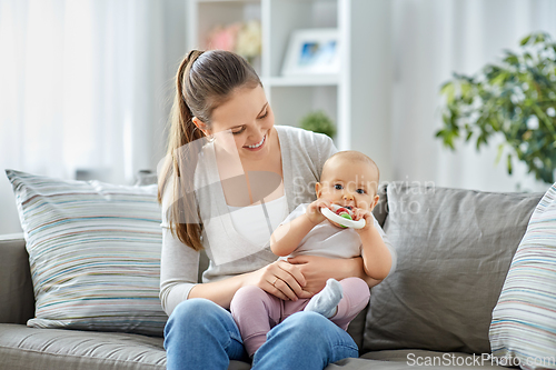 Image of mother and little baby with teething toy at home