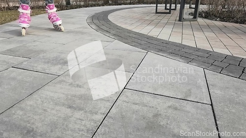 Image of Little girl in roller skates at a park
