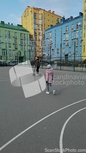 Image of Mother and daughter ride on a scooter in the city