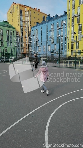 Image of Mother and daughter ride on a scooter in the city