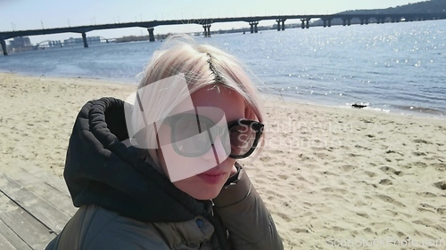 Image of Close up portrait of young glamorous caucasian lady in sunglasses. Enjoying from lifestyle, turning to side of head hair waving in wind.