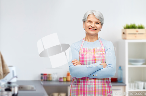 Image of portrait of smiling senior woman at kitchen