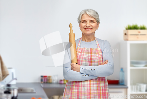 Image of smiling senior woman with rolling pin at kitchen