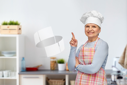 Image of senior woman or chef pointing finger up at kitchen