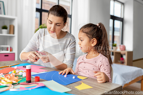 Image of daughter with mother making applique at home