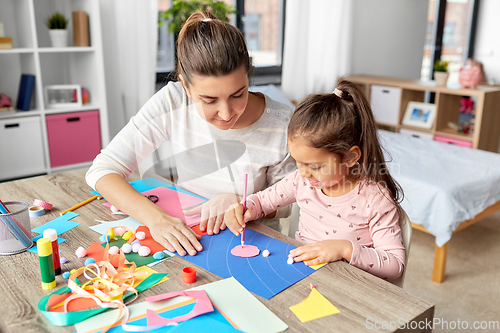 Image of daughter with mother making applique at home