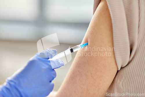 Image of close up of hand with syringe vaccinating patient