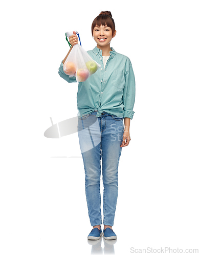 Image of happy woman with apples in reusable net bag