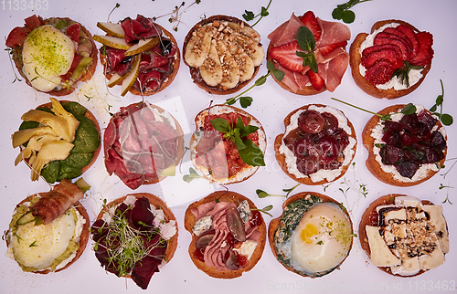 Image of Crostini with different toppings on white background. Delicious appetizers.