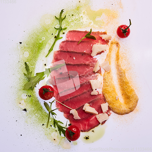 Image of Sliced pieces of fried beef pastrami with colored sauces