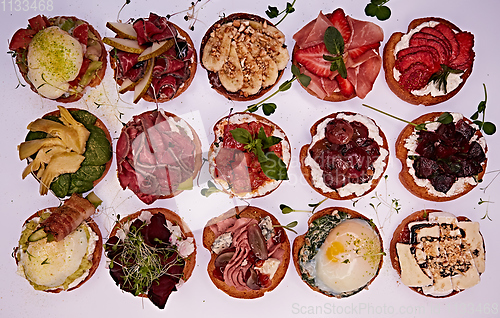 Image of Crostini with different toppings on white background. Delicious appetizers.