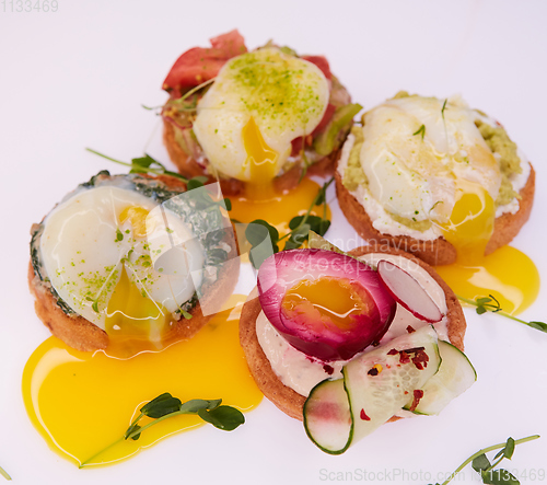 Image of Four different toasts with poached egg.