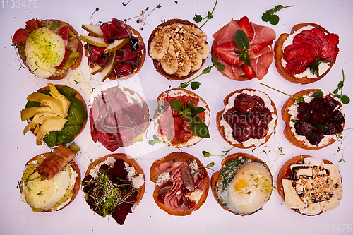 Image of Crostini with different toppings on white background. Delicious appetizers.