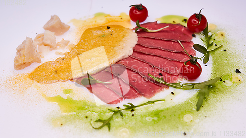 Image of Sliced pieces of fried beef pastrami with colored sauces