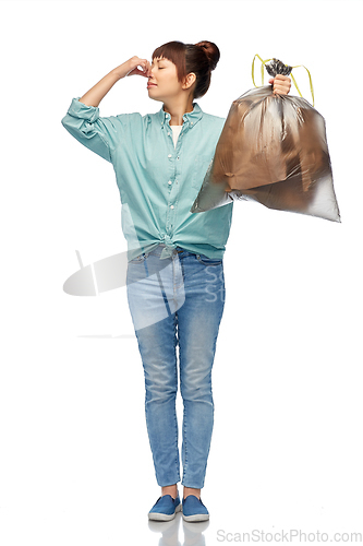 Image of asian woman holding smelly trash in plastic bag