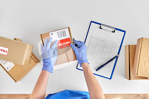 Image of hands in gloves with returned parcel box