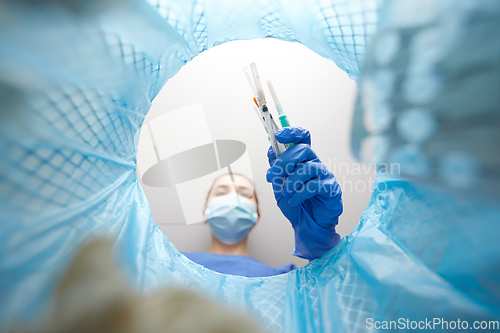 Image of doctor throwing used syringes into trash can