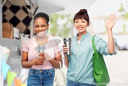 Image of women with tumblers and bags over food truck