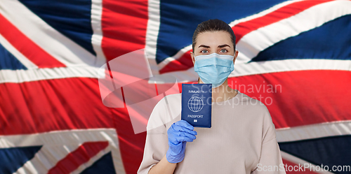 Image of woman in mask and gloves holding immunity passport