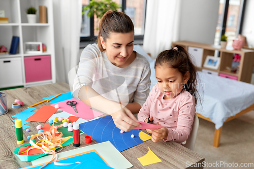 Image of daughter with mother making applique at home