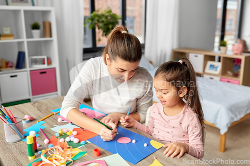 Image of daughter with mother making applique at home