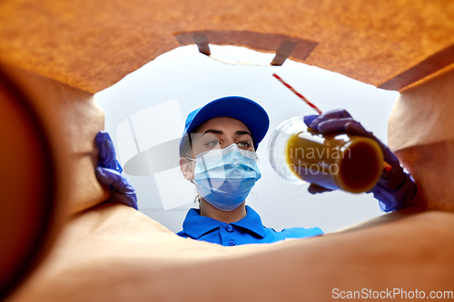 Image of delivery girl in gloves and mask with food in bag