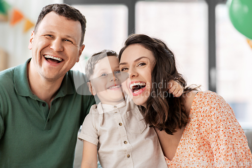 Image of happy family with little son at birthday party