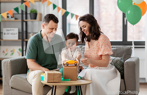 Image of happy family opening birthday presents at home