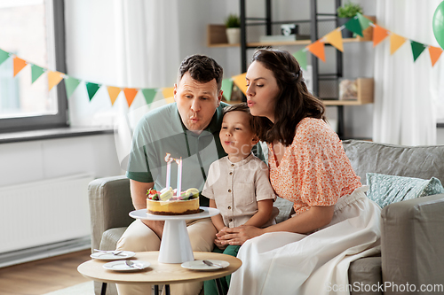 Image of happy family with birthday cake at home