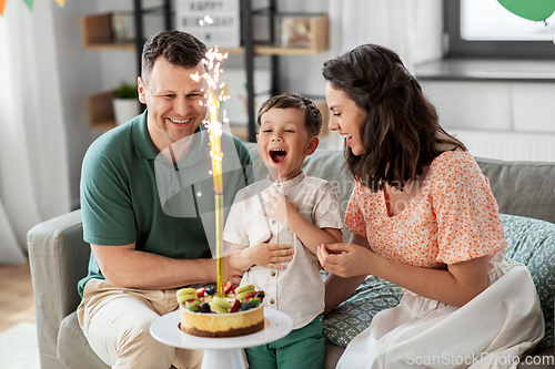 Image of happy family with birthday cake at home