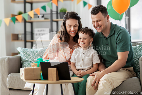 Image of happy family with tablet pc at home on birthday