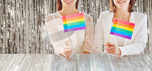 Image of close up of happy lesbian couple with rainbow flag