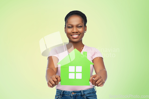 Image of smiling african american woman holding green house