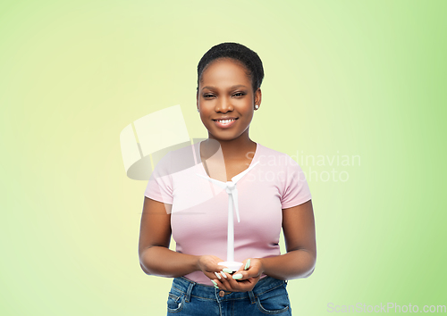 Image of happy african american woman with toy wind turbine