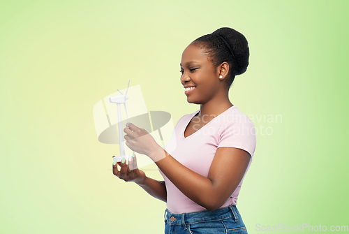 Image of happy african american woman with toy wind turbine