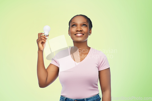 Image of african american woman holding lighting bulb