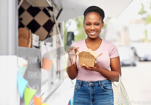 Image of happy woman with reusable string bag eating wok