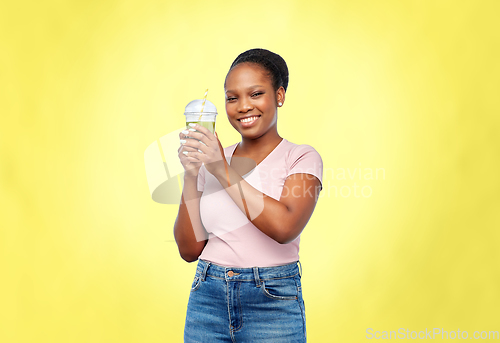 Image of happy african american woman drinking green juice