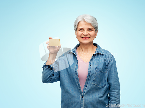 Image of portrait of smiling senior woman with credit card